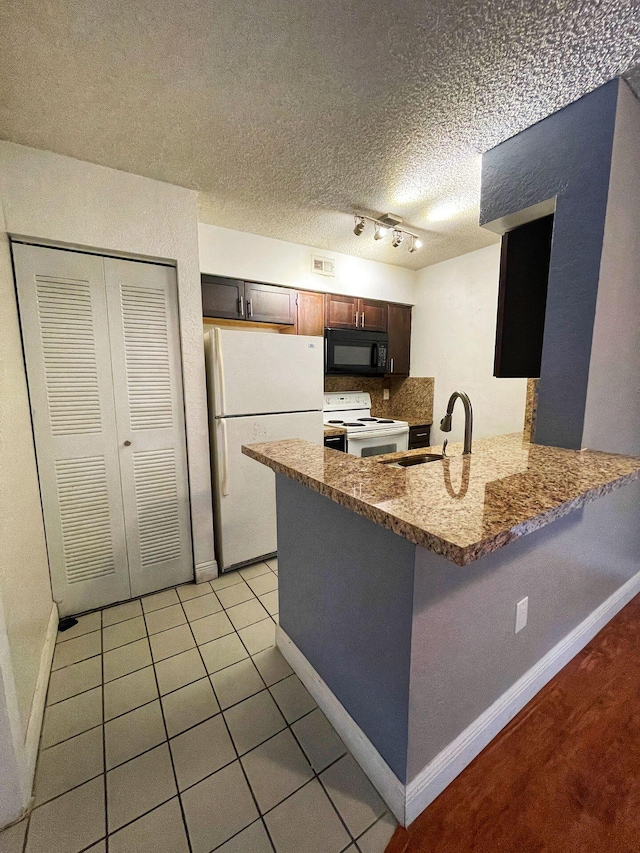 kitchen with white appliances, sink, a textured ceiling, kitchen peninsula, and track lighting