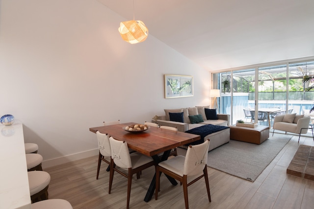 dining area featuring high vaulted ceiling and hardwood / wood-style flooring