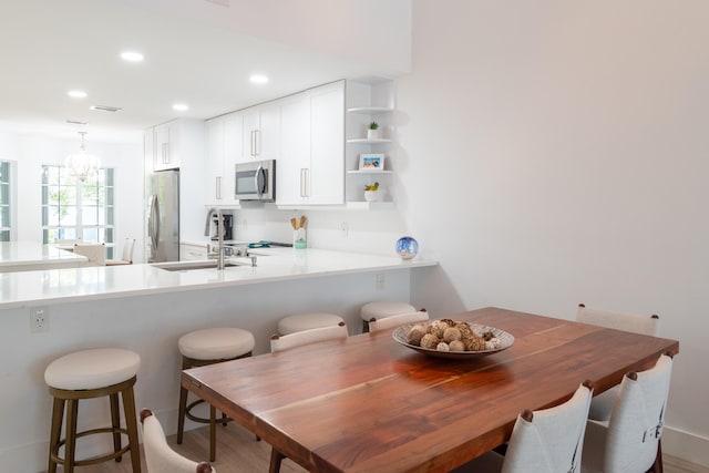 dining space featuring sink and an inviting chandelier