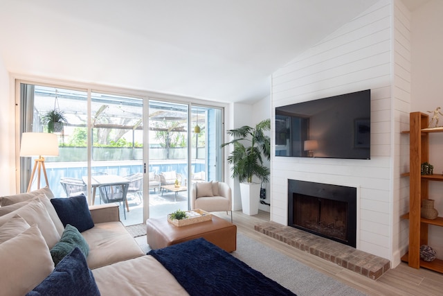 living room featuring a fireplace, hardwood / wood-style flooring, and lofted ceiling