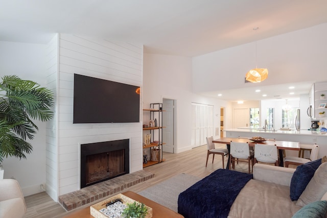 living room with a large fireplace and light wood-type flooring