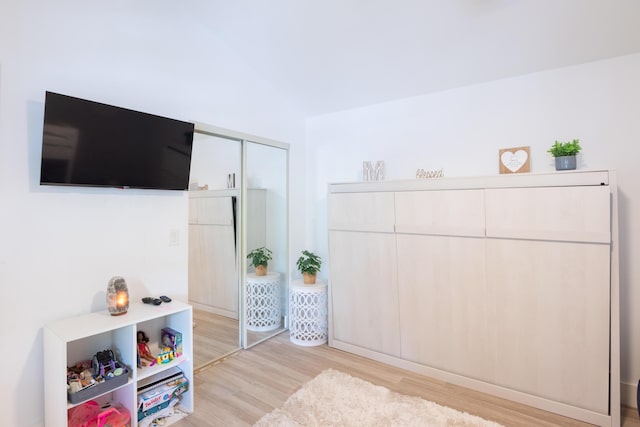 bedroom with light hardwood / wood-style floors and a closet