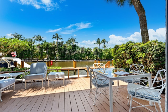 deck featuring a water view and outdoor dining area