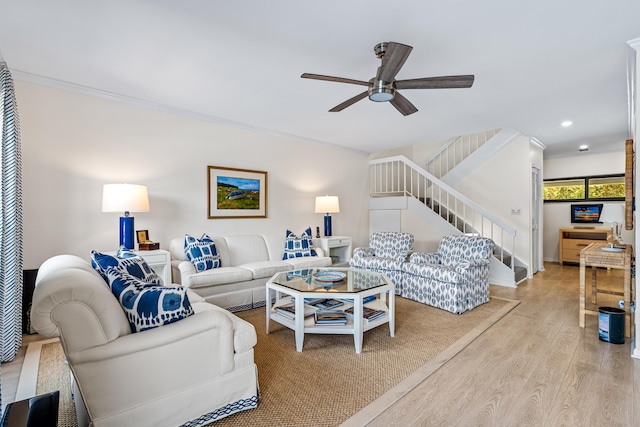 living room featuring crown molding, ceiling fan, and light hardwood / wood-style floors