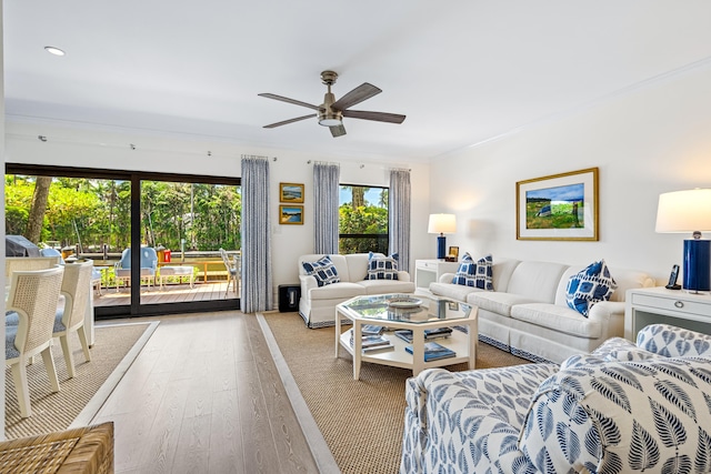 living room with ornamental molding, ceiling fan, and wood finished floors