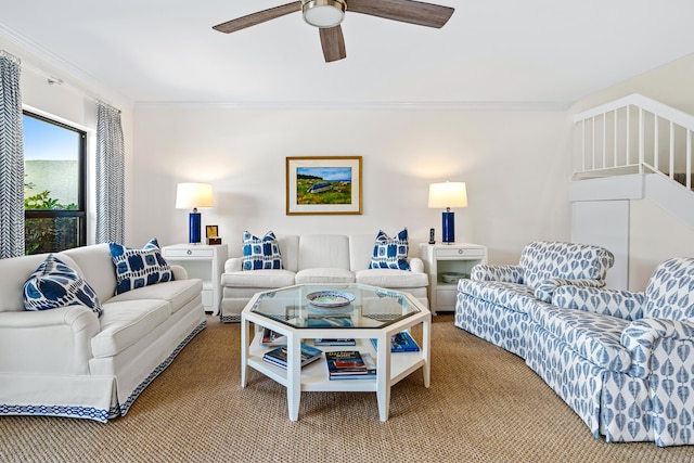 carpeted living room with crown molding and ceiling fan