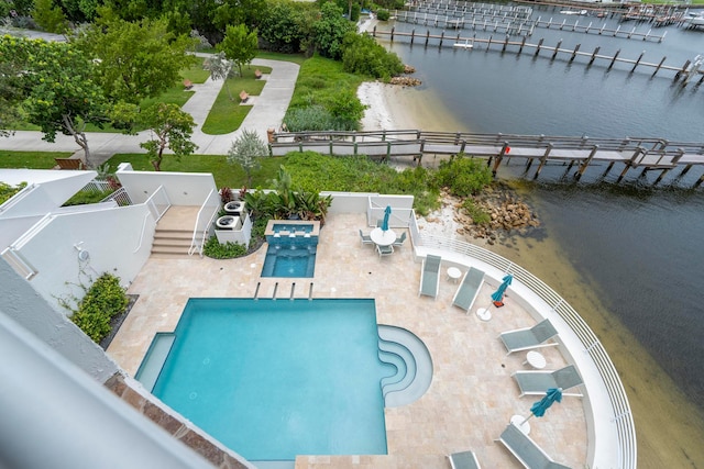 view of swimming pool with a water view and a patio area