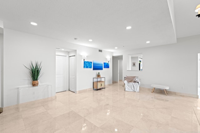 tiled living room featuring a textured ceiling