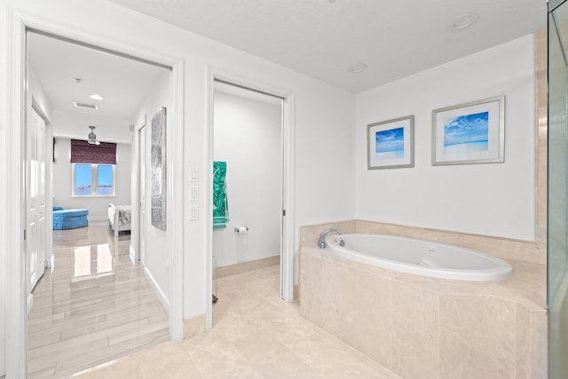 bathroom featuring a relaxing tiled tub and tile patterned floors