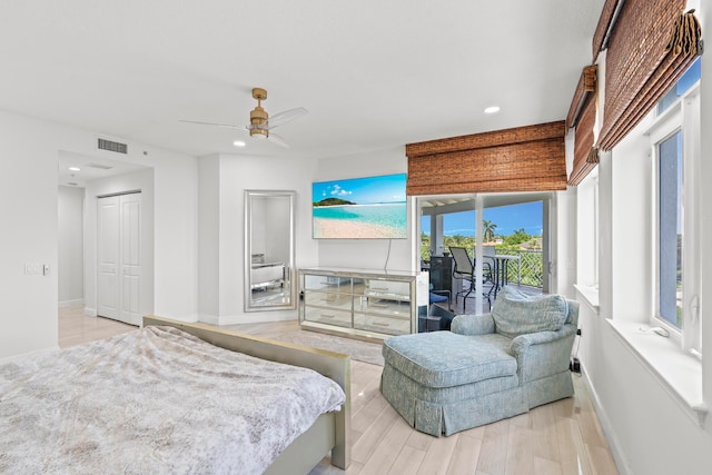 bedroom with access to exterior, ceiling fan, light hardwood / wood-style flooring, and a closet