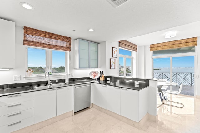 kitchen featuring sink, white cabinets, dishwasher, and light tile patterned floors