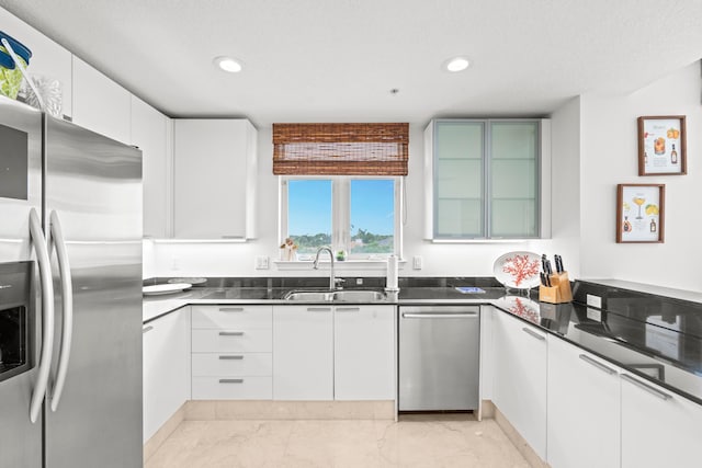 kitchen with white cabinetry, stainless steel appliances, sink, and light tile patterned floors