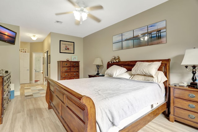 bedroom with ensuite bath, light hardwood / wood-style flooring, and ceiling fan