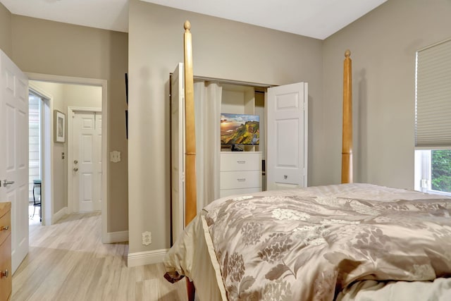 bedroom with light hardwood / wood-style floors and a closet