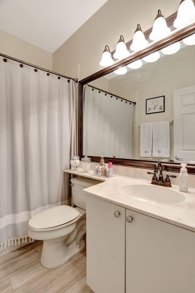 bathroom featuring vanity, hardwood / wood-style floors, and toilet