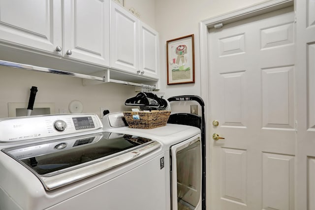 washroom with washing machine and clothes dryer and cabinets