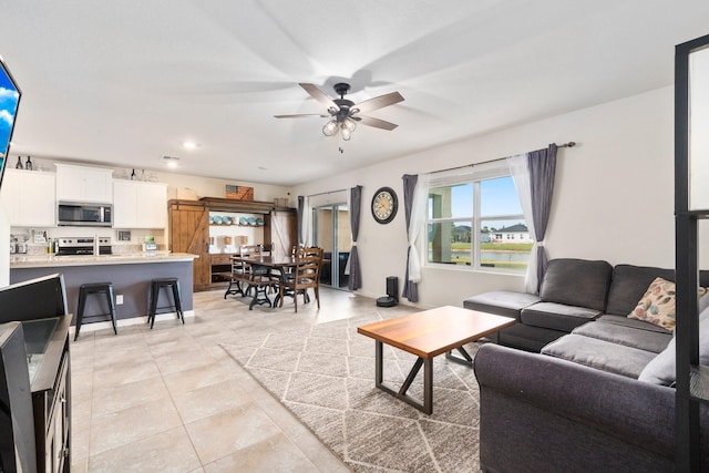 living room featuring ceiling fan and light tile patterned floors