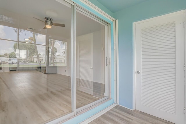 unfurnished sunroom featuring ceiling fan