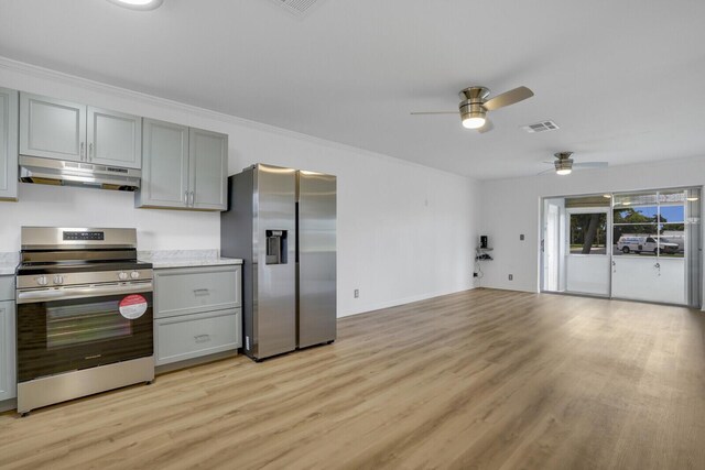 kitchen with appliances with stainless steel finishes, gray cabinetry, light hardwood / wood-style floors, and ornamental molding