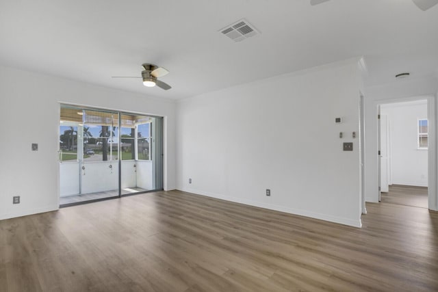 empty room with hardwood / wood-style flooring, ornamental molding, and ceiling fan