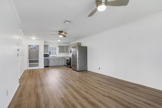 unfurnished living room featuring crown molding, wood-type flooring, and sink