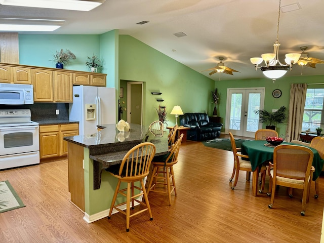 kitchen featuring light hardwood / wood-style flooring, white appliances, french doors, pendant lighting, and a kitchen bar
