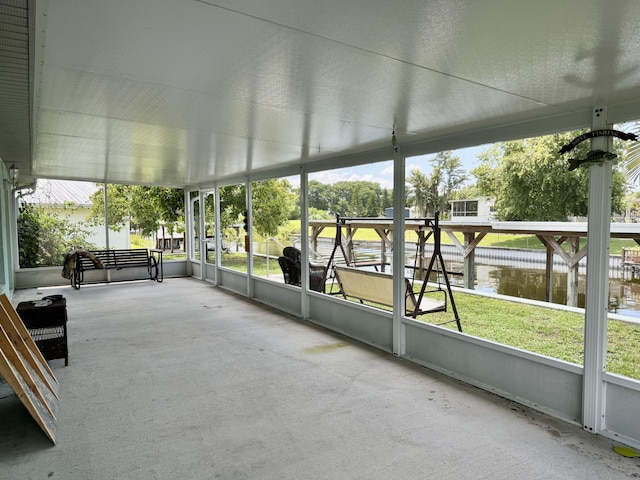 unfurnished sunroom featuring a water view