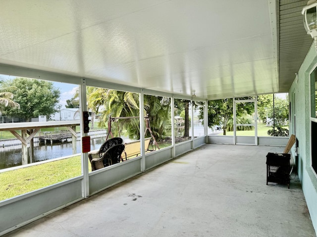 unfurnished sunroom with a water view