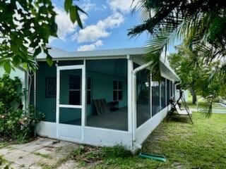 view of home's exterior featuring a yard and a sunroom