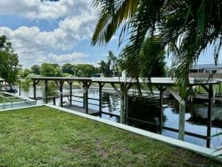 dock area featuring a lawn and a water view
