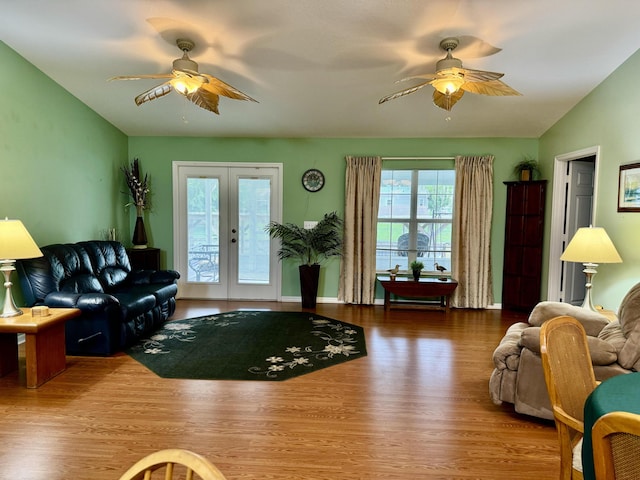 living room with hardwood / wood-style floors, french doors, plenty of natural light, and vaulted ceiling