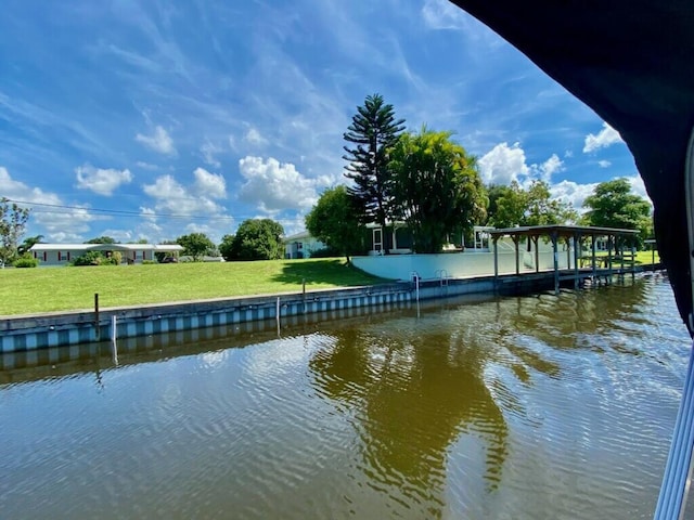 dock area featuring a water view and a lawn