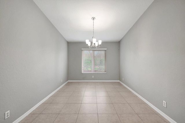 unfurnished room featuring a notable chandelier and light tile patterned floors