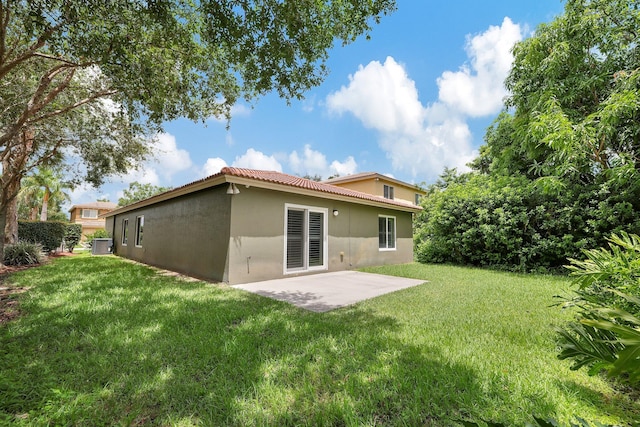 rear view of property featuring a patio area and a yard