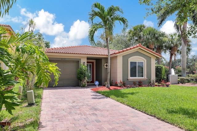 mediterranean / spanish-style home featuring a garage and a front yard