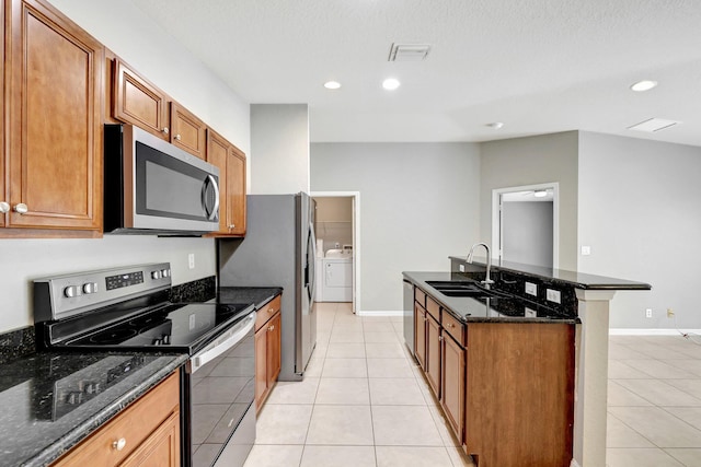 kitchen featuring sink, light tile patterned floors, independent washer and dryer, and stainless steel appliances