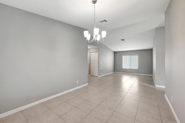 tiled empty room featuring a chandelier