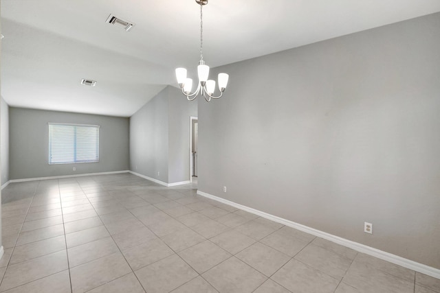 tiled spare room with an inviting chandelier