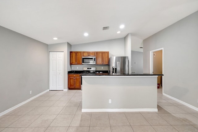 kitchen featuring lofted ceiling, a center island, stainless steel appliances, and light tile patterned floors