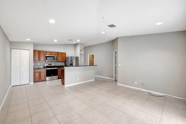 kitchen featuring a center island, vaulted ceiling, appliances with stainless steel finishes, and light tile patterned floors