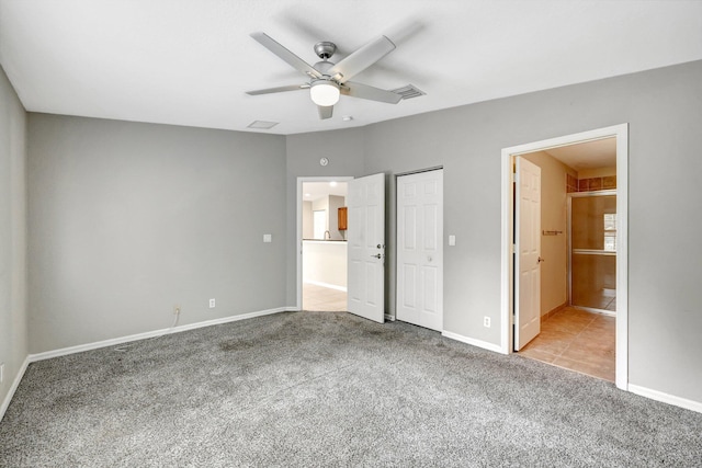 unfurnished bedroom with light carpet, ceiling fan, and connected bathroom