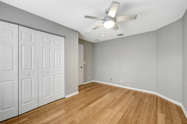 unfurnished bedroom featuring light wood-type flooring, ceiling fan, and a closet