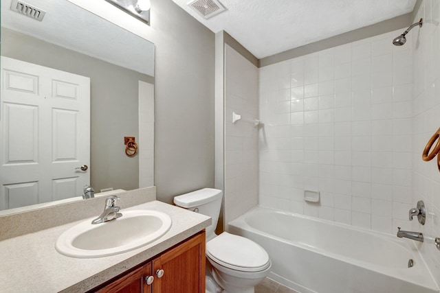 full bathroom with a textured ceiling, toilet, vanity, and tiled shower / bath