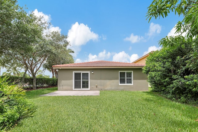 rear view of house with a patio area and a lawn