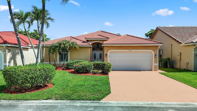 mediterranean / spanish-style house featuring a garage and a front yard