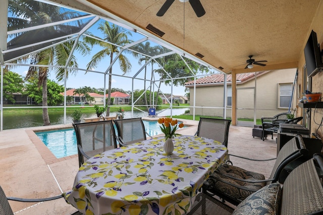 sunroom featuring a water view and ceiling fan