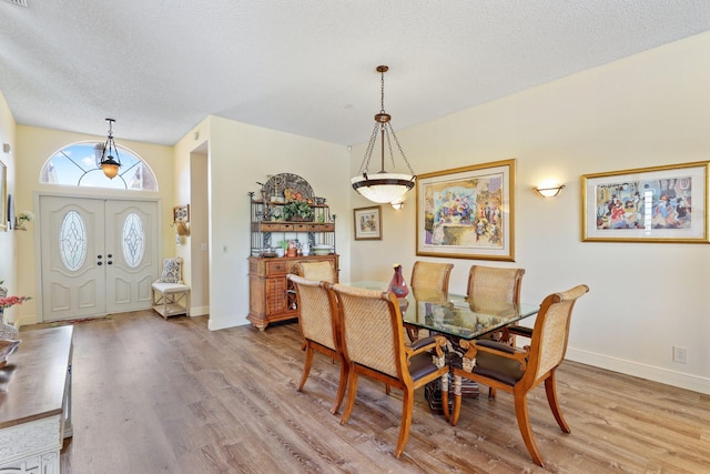 dining space featuring a textured ceiling and hardwood / wood-style floors