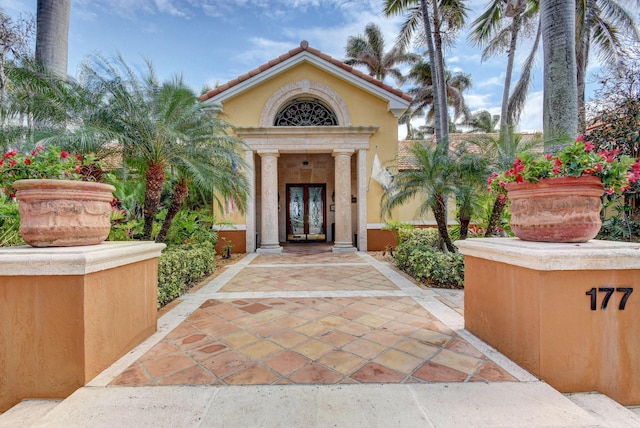 property entrance with stucco siding and french doors