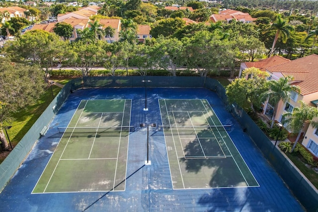 view of sport court with fence and a residential view