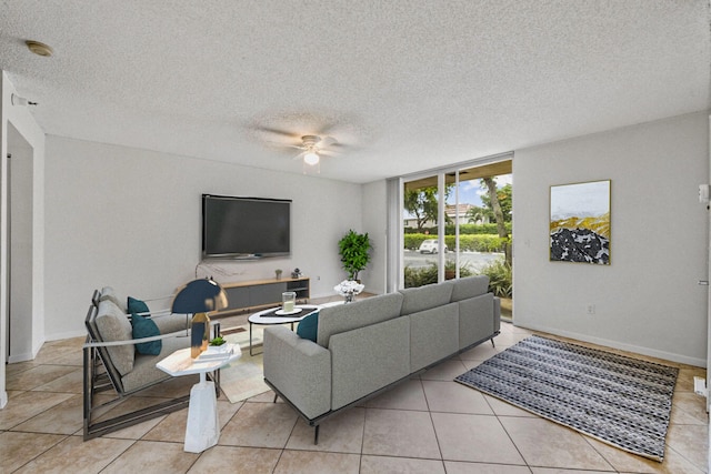 living room with ceiling fan, light tile patterned flooring, a textured ceiling, and floor to ceiling windows